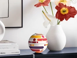 Composition décorative avec La Petite Boule Miami et un vase blanc sur un buffet clair.