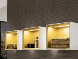 Une étagère suspendue Finion blanche avec lumière Une étagère suspendue Finion blanche avec éclairage sur mur marron.