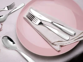 Des couverts de table Rose Garden sur une assiette rose Des couverts de table Rose Garden de Villeroy & Boch sur une assiette Rose Garden rose ornée de petites fleurs.