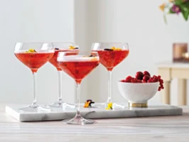 Des coupes à champagne Purismo avec des baies Quatre coupes à champagne de la collection Purismo avec des baies sur un plateau.