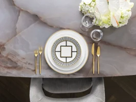 Une table élégamment dressée avec de la vaisselle MetroChic élégante et des couverts de table MetroChic dorés Une table pleine de style avec une élégante vaisselle MetroChic, des couverts de table dorés et un centre de table floral sur une table en marbre.
