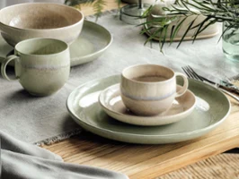 Des assiettes Perlemor vertes et beiges sur une table en bois Une décoration de table rustique avec des assiettes et des tasses Perlemor dans des tons terreux discrets sur une table en bois.