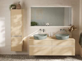 Une salle de bains bohème avec des WC et un bidet Une salle de bains bohème moderne de Villeroy & Boch avec des WC muraux Venticello et un bidet sur un sol en galets. Une plante décorative et un panier en osier sont posés sur un rebord en bois au-dessus.