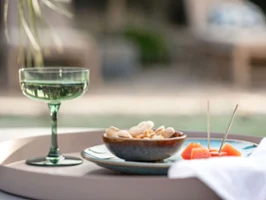 Une décoration de table en extérieur avec un verre Like Sage et un bol Lave Un verre Like Sage, un bol de crackers Lave et des tranches d’orange sur un plateau à l’extérieur.