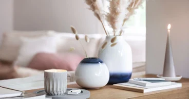 Vases Lave bleu et blanc avec une bougie parfumée Perlemor Avec un vase Lave en petit et grand format, le style bohème s’invitera sur le buffet de votre salle à manger.