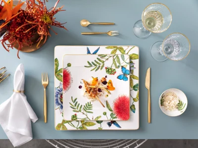 Une assiette Amazonia à motif botanique avec des couverts de table dorés MetroChic de Villeroy & Boch Une décoration de table élégante avec une assiette Amazonia de style botanique, des couverts dorés MetroChic et des verres modernes.