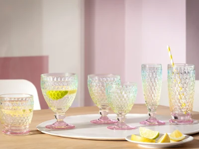 Ensemble de six verres Boston Pearl Un ensemble de six verres Villeroy & Boch Boston Pearl sur une table en bois avec des tranches de citron vert et de citron, un verre avec une paille et une tranche de citron.
