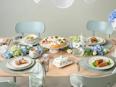 Une table dressée pour quatre personnes sur le thème Easter Delight Une table dressée pour quatre personnes sur le thème Easter Delight avec des décorations Easter Delight, de la vaisselle aux couleurs pastel et des assiettes soigneusement disposées.