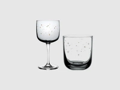 Image de la collection - Verres Winter Glow Un verre à vin et un gobelet, tous deux transparents et ornés de petits motifs à pois, se détachent sur un fond clair et sobre.