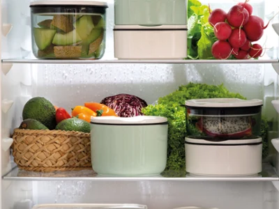 Contenants ToGo empilés dans le réfrigérateur ToGo de Villeroy & Boch propose des boîtes de conservation bien organisées pour les fruits et légumes frais comme les légumes à feuilles, les poivrons, les radis et les agrumes dans votre réfrigérateur.