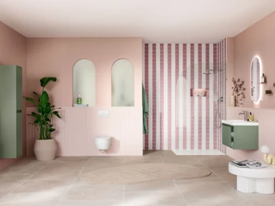 Salle de bains moderne avec des murs roses, un espace douche rayé, des touches de vert, de grands miroirs et une plante en pot.