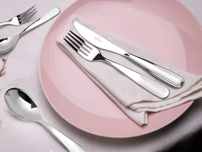 Des couverts de table Rose Garden sur une assiette rose Des couverts de table Rose Garden de Villeroy & Boch sur une assiette Rose Garden rose ornée de petites fleurs.