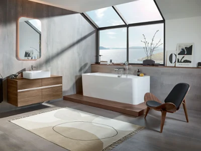 Une salle de bains moderne avec un sol en bois et une élégante baignoire Collaro de Villeroy & Boch.