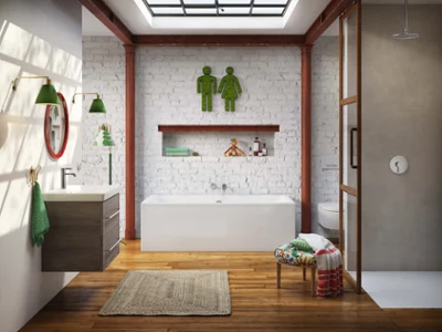 Une salle de bains moderne avec un plancher en bois, une baignoire, un espace douche et un lavabo. Les éléments de décoration verts comprennent des appliques murales, des serviettes et un symbole représentant deux personnages au-dessus de la baignoire devant un mur de briques blanches.