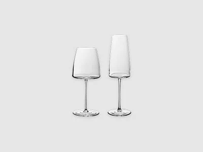 Image de la collection - Verres MetroChic Deux verres à vin vides aux pieds transparents sont posés côte à côte sur un fond gris clair sobre.