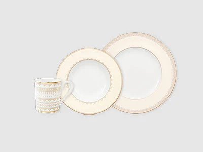 Image de la collection - Ivoire Une tasse blanche et deux assiettes blanches à bord doré sont disposées sur un fond clair et sobre.