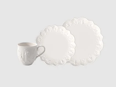 Image de la collection - Toy's Delight Royal Classic Une tasse en céramique blanche et deux assiettes blanches ondulées sont disposées sur un fond clair et sobre.