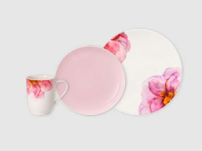 Image de la collection - Rose Garden Une tasse, une assiette et une assiette-repas en céramique avec des motifs floraux roses et une solide finition rose clair sur fond clair.