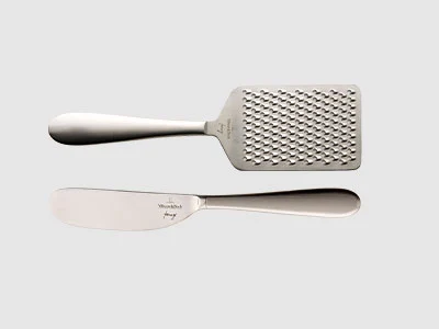 Image de la collection - Kensington Deux ustensiles de cuisine en acier inoxydable : une râpe et un couteau à tartiner, représentés sur un fond clair et sobre.