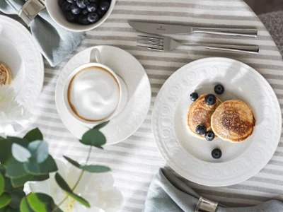 Service de table avec la collection Cellini de Villeroy & Boch Service de table avec la collection Cellini de Villeroy & Boch, comprenant une tasse à café, des crêpes aux myrtilles et des couverts.