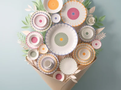 Une composition florale d'ustensiles de cuisine avec différentes assiettes et bols. Une composition florale d'ustensiles de cuisine avec différentes assiettes et bols décorés de motifs de fruits, enveloppés dans du papier brun et attachés avec un ruban bleu clair, sur un fond bleu clair.