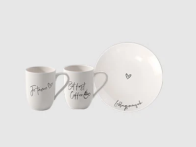 Image de la collection - Statement Deux tasses blanches et une assiette blanche avec un texte manuscrit noir et une petite illustration de cœur sur chaque article.