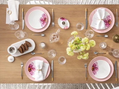 Table dressée avec de la vaisselle et des couverts de table Rose Garden Une table dressée avec des assiettes et des couverts de table roses et blancs de la collection Rose Garden de Villeroy & Boch.