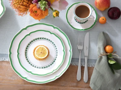 Des assiette French Garden de Villeroy & Boch avec un dessert au citron Une table rustique dressée avec des assiettes French Garden, un délicieux dessert au citron, une tasse à café et des fleurs fraîches.