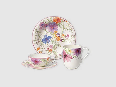 Image de la collection - Mariefleur Un service à thé au motif floral, composé d'une assiette, d'une soucoupe et de deux tasses sur un fond clair et sobre.