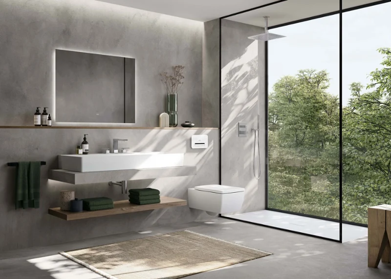 Une salle de bains minimaliste avec des lavabo Memento 2.0 de Villeroy & Boch et des toilettes suspendues.  Le design combine des lignes nettes, des murs gris discrets et une douche à l’italienne avec vue sur la verdure.