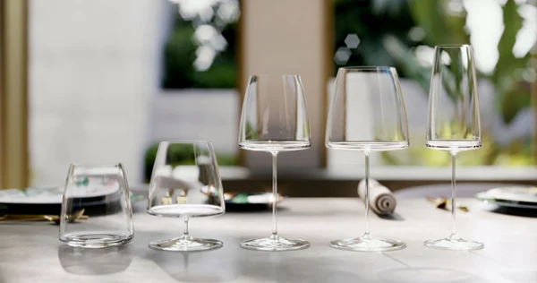 Des verres MetroChic sur une table polie, élégamment disposés, avec un décor de jardin flou en arrière-plan.