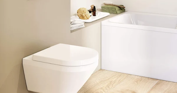 Des WC Architectura dans une salle de bains scandinave Des toilettes Architectura blanches avec une plaque de déclenchement dans une salle de bains beige au look scandinave