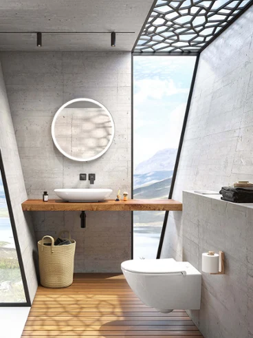 Une salle de bains moderne avec des murs en béton, une grande fenêtre donnant sur un lac, un miroir rond Subway 3.0 et une vasque à poser blanche Loop & Friends.