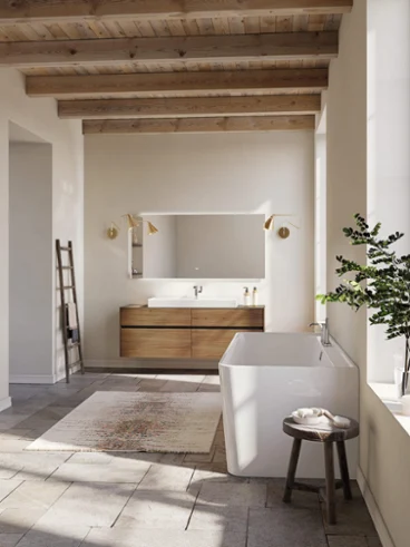 Salle de bain Collaro avec poutres en bois, baignoire blanche et meuble-lavabo en chêne. Salle de bain Collaro chaleureuse avec poutres de plafond en bois, baignoire blanche et meuble-lavabo aux tons de chêne naturel. La lumière du jour douce et les teintes neutres créent un refuge douillet de style champêtre.