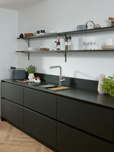 Une robinetterie de cuisine Subway Style Shower dans une cuisine noire Une robinetterie de cuisine Subway Style Shower en acier inoxydable massif dans une cuisine noire avec des étagères et un évier.