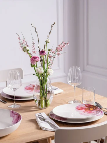 Une table dressée de façon moderne pour quatre personnes avec de la vaisselle et un vase Rose Garden Une table de salle à manger moderne dressée pour quatre personnes avec une élégante vaisselle Rose Garden de Villeroy & Boch et un vase de fleurs de la collection Rose Garden.