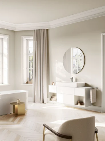 Intérieur de salle de bain lumineux présentant la collection Villeroy & Boch Vea avec un élégant mitigeur de lavabo et une baignoire îlot dans une harmonie moderne et intemporelle.