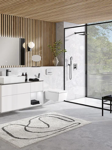 Un lavabo et des WC Memento 2.0 blancs dans une salle de bains moderne Une salle de bains moderne avec un plafond en bois moderne et un lavabo Memento 2.0 blanc ainsi que des toilettes.