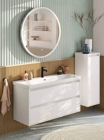 Espace de lavage généreux en blanc avec la collection Skyla de Villeroy & Boch. Espace de lavage moderne et spacieux dans des couleurs pastel composé d'un meuble-lavabo avec meuble bas blanc, d'un miroir rond éclairé, d'un meuble d'appoint et d'une robinetterie noire de la collection de salle de bain Skyla.