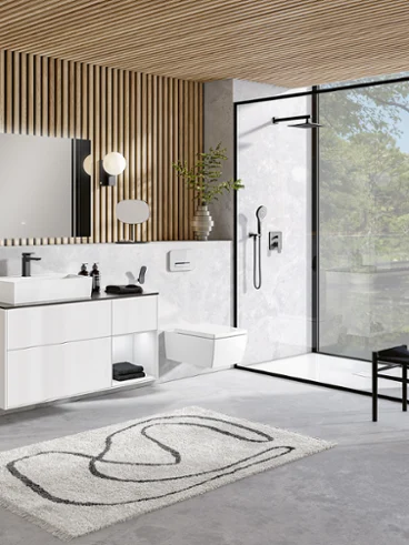 Un lavabo et des WC Memento 2.0 blancs dans une salle de bains moderne Une salle de bains moderne avec un plafond en bois moderne et un lavabo Memento 2.0 blanc ainsi que des toilettes.