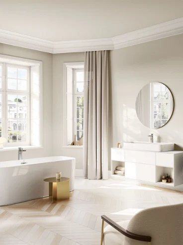 Intérieur de salle de bain lumineux présentant la collection Villeroy & Boch Vea avec un élégant mitigeur de lavabo et une baignoire îlot dans une harmonie moderne et intemporelle.