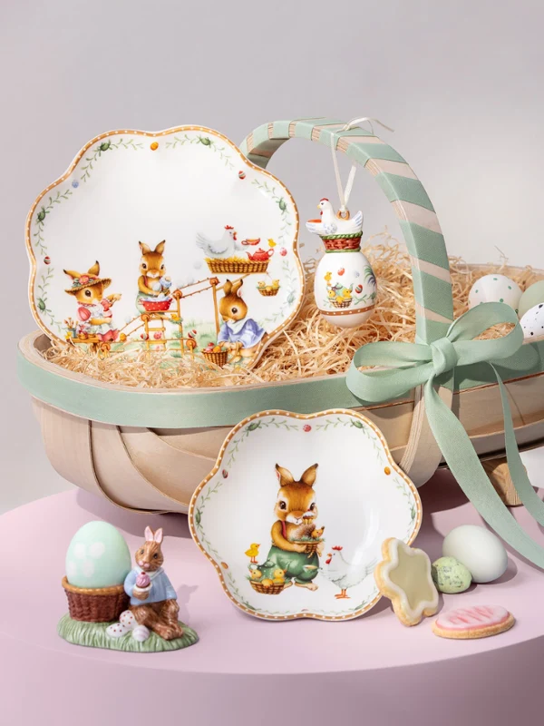 Annual Easter Edition 2026 service de table décoré sur une table Vaisselle Annual Easter Edition 2026 avec motifs de lapins, œufs, tasse et biscuits disposés sur des supports aux tons pastel.
