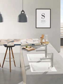 Un évier de cuisine Subway dans un plan de travail gris Une cuisine moderne avec deux éviers de cuisine blancs, des placards de cuisine intégrés et un comptoir avec des tabourets.