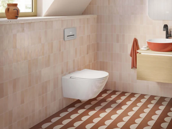 Des toilettes Universo TwistFlush avec un lavabo Artis orange Une salle de bains moderne avec des toilettes Universo TwistFlush, un plan de toilette en bois avec un lavabo Artis orange et un carrelage à motifs au sol