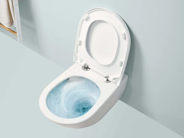 Des toilettes Subway 3.0 avec l’abattant relevé Des toilettes Subway 3.0 blanches avec l’abattant relevé, dans lesquelles on peut voir de l’eau bleue tourbillonnant devant un mur bleu clair