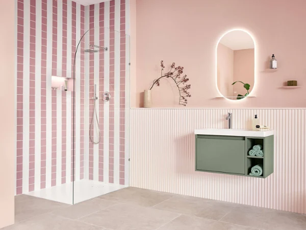 Vasque Skyla vert doux sur mur rose pastel Vasque Skyla vert doux avec espace de rangement, mural sur fond rose pastel et douche en blanc alpin