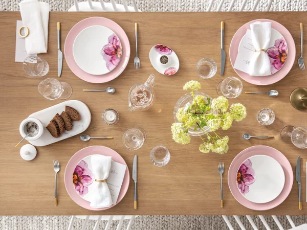 Table dressée avec de la vaisselle et des couverts de table Rose Garden Une table dressée avec des assiettes et des couverts de table roses et blancs de la collection Rose Garden de Villeroy & Boch.