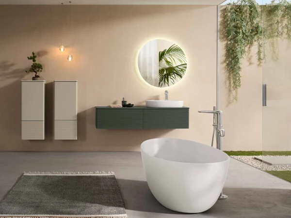 Une salle de bains complète et moderne avec des meubles, de la céramique, un miroir lumineux et une baignoire de la collection Villeroy & Boch Antao dans des tons naturels et avec des plantes vertes.