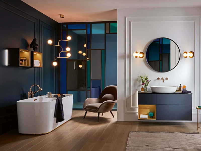 Une baignoire Finion dans une salle de bains classique en bleu foncé Une baignoire Finion dans une salle de bains classique avec des murs bleus et un sol en bois.