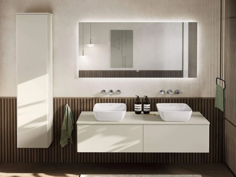 Un coin lavabo d’une salle de bains de style japandi Une salle de bains japandi avec un grand miroir, un lavabo « Artis », un plan de toilette « Finion » et des meubles en bois blanc « Finion ».